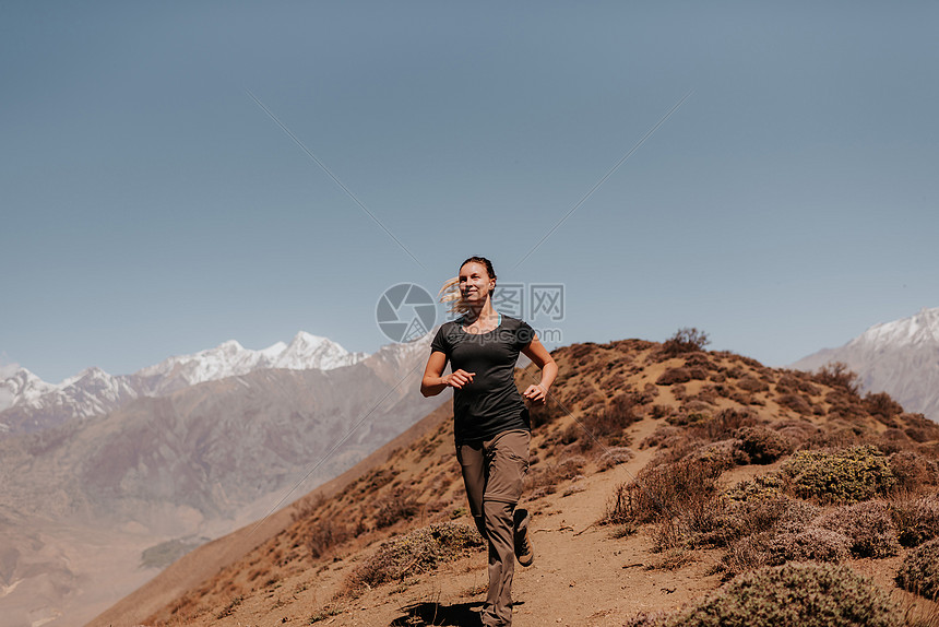 妇女从山顶上慢跑下来AnnapurnaCircular喜马拉雅山Muktinath尼泊尔图片