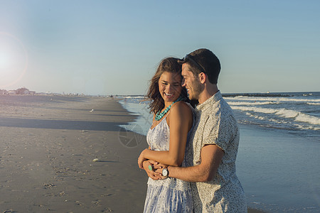 美国新泽西州春湖海滩上抱着浪漫的年轻夫妇图片