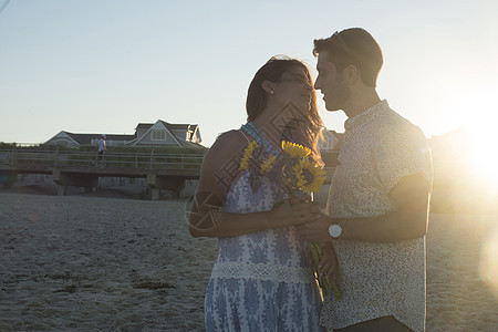 美国新泽西州春湖日落时在海滩面对的浪漫年轻夫妇图片