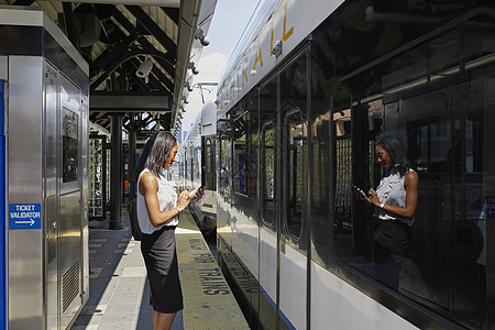 在火车站使用手机的女商人图片