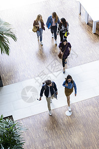 男大学生和女在前厅走和说话高角度视图片