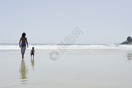 父亲和儿子在海滩上散步图片