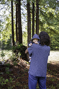 成熟的男子在森林中怀着小儿子肖像图片