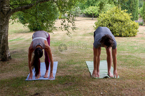 男人和女在花园里做瑜伽弯腰图片