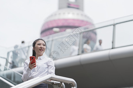 上海市楼梯拿着手机的年轻女商人图片