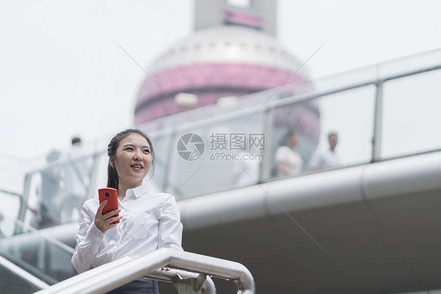 上海市楼梯拿着手机的年轻女商人图片