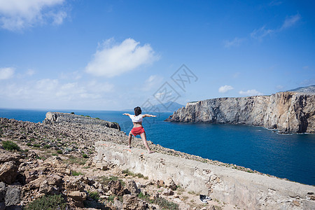 在意大利撒丁岛伊格莱西亚斯的山顶上做瑜伽的妇女图片