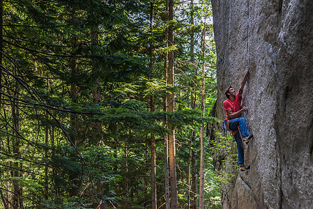 攀岩者在靠近树木的岩石表面攀爬斯阔米什加拿大图片
