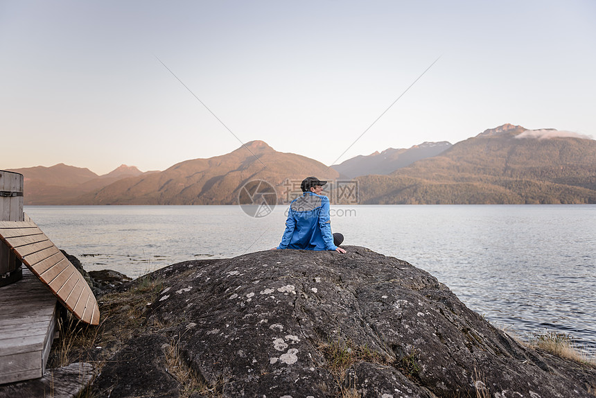 加拿大约翰斯通海峡湖边坐在石头上看风景的女人图片