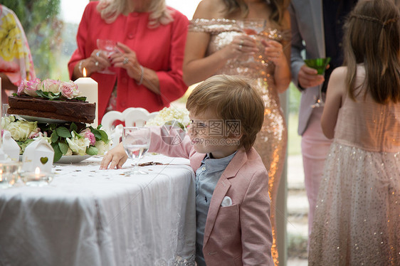 男孩子对婚礼堂的物和蛋糕很好奇图片