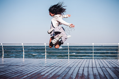 在乌克兰奥德萨斯塔州萨海码头空中跳跃的成年妇女图片
