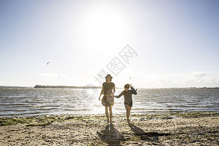 母亲和女儿在海滩上手牵手图片