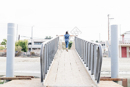 美国加利福尼亚州长滩交叉桥张开双臂的女孩图片