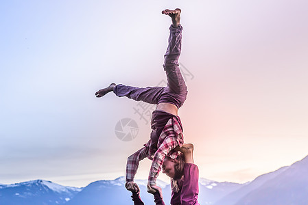 加拿大不列颠哥伦比亚省两名年轻妇女日落时在山上练瑜伽图片