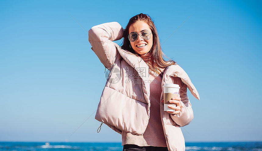 成年女子在海滩上端着咖啡摸着头发乌克兰图片