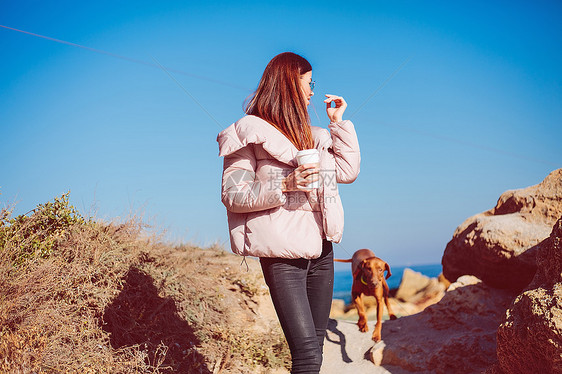 乌克兰奥德萨斯塔州萨在海滩上带着狗散步的成年妇女图片