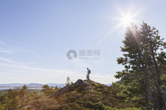 男孩和父亲从林地的山丘向外望图片