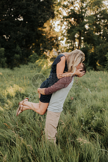 浪漫的男人在长草田里抬起女朋友图片