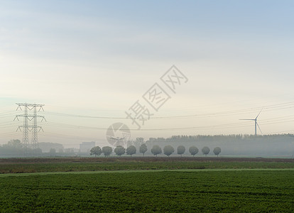 风力涡轮机和电线在雾的早晨风景荷兰图片