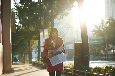 韩国首尔市商业妇女边走边读报纸图片