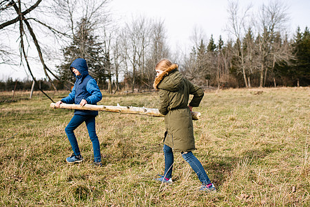两个孩子在田间搬木头图片素材