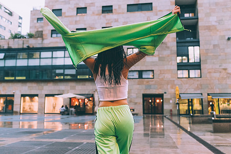 女人在雨中张开双臂抬起头意大利米兰市广场图片