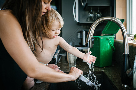 厨房水槽中母亲洗碗儿子去玩水图片