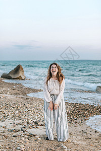 年轻女子在海滩上开心大笑图片