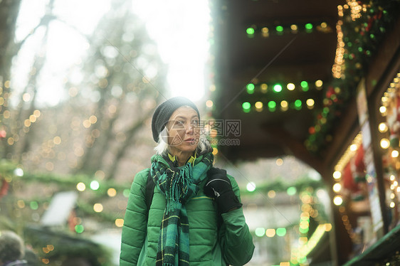 圣诞节走在街上看着商店橱窗的女人图片