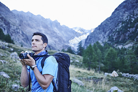瑞士瓦莱州登山者拿着相机准备拍照图片