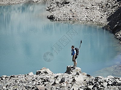 瑞士瓦莱斯马特洪峰塞文山湖边岩石上的徒步旅行者图片