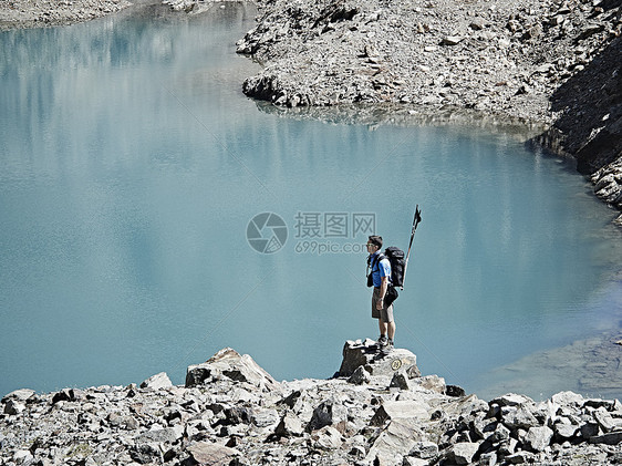 瑞士瓦莱斯马特洪峰塞文山湖边岩石上的徒步旅行者图片