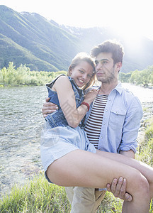 年轻男子带女友在河边图片