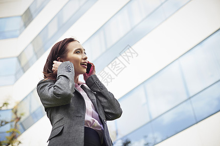 办公室外讲智能电话的年轻女商业青图片