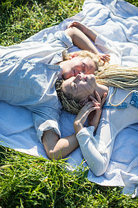 西班牙躺在草地野餐毯上的小情侣图片