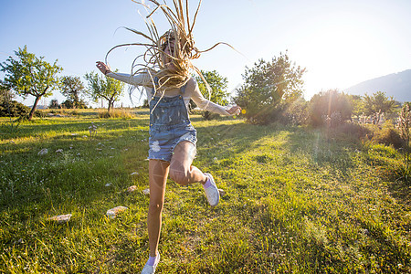 西班牙马略卡年轻女子在田野里欢蹦乱跳图片