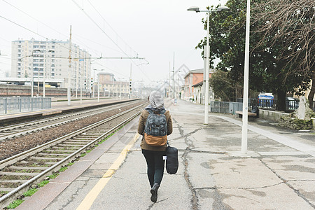 铁路平台上女人背着包的背影图片
