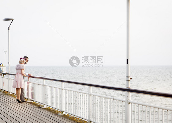 一对打扮复古的老年夫妻从码头看海图片