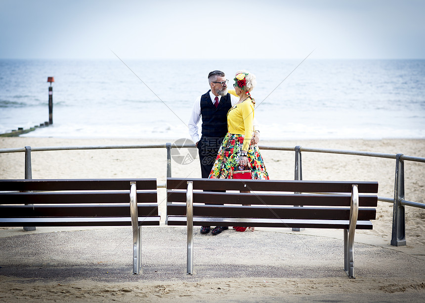 打扮复古的老年夫妻在海滩对视图片