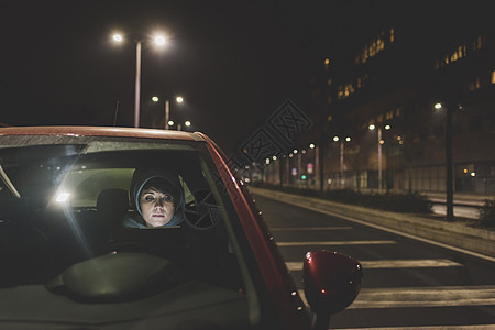 晚上在城市路边开车的女人图片