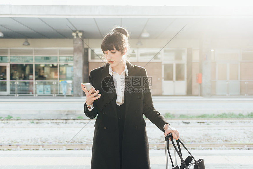 意大利米兰火车站使用移动电话的女商人图片