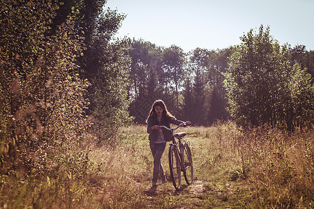 少女在田里推自行车图片