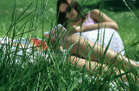 草地上看书的女人图片