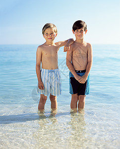 两个男孩站在大海里图片