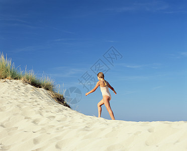 女孩在沙滩上走路图片