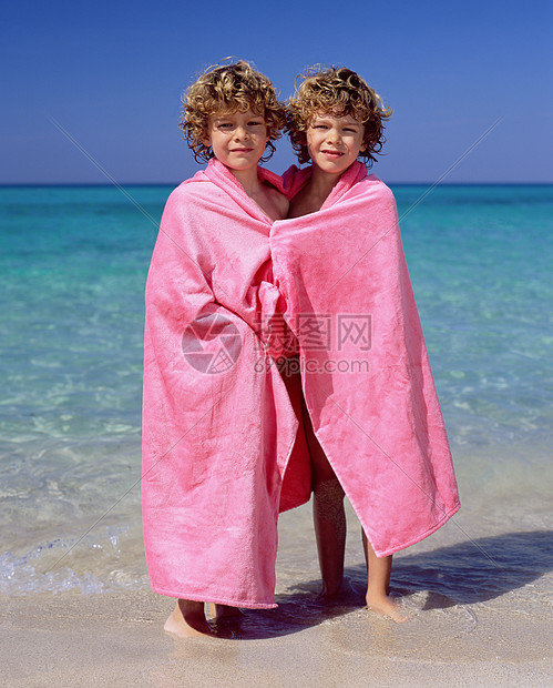 双胞胎男孩在海边玩耍图片