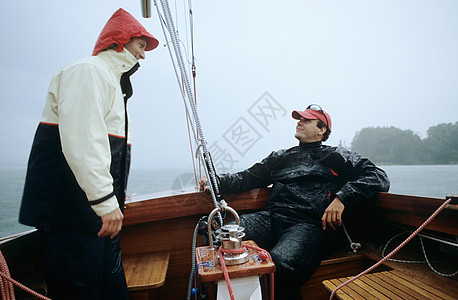 在雨中乘船的两个男人图片