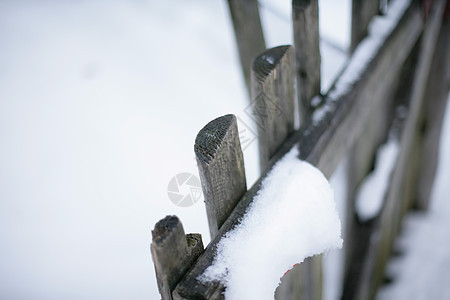 在栅栏上下雪背景图片