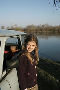 女孩站在河边的车图片