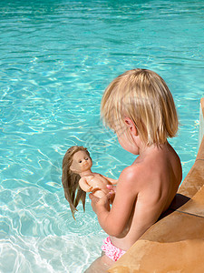 在游泳池里玩娃的男孩图片